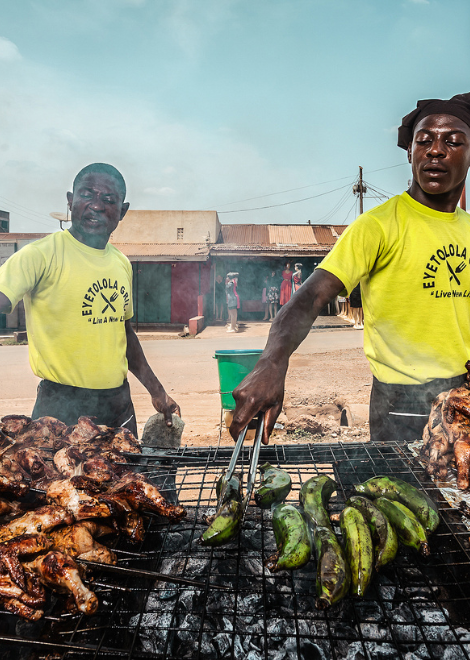 Vendors cooking matoke and chicken over hot charcoal
