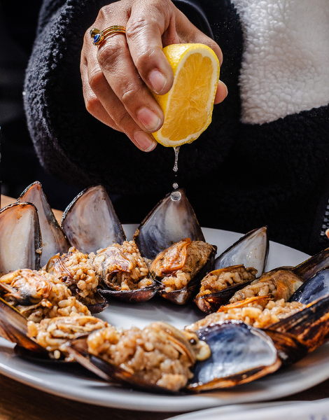 A squeeze of lemon over midye dolma stuffed mussels