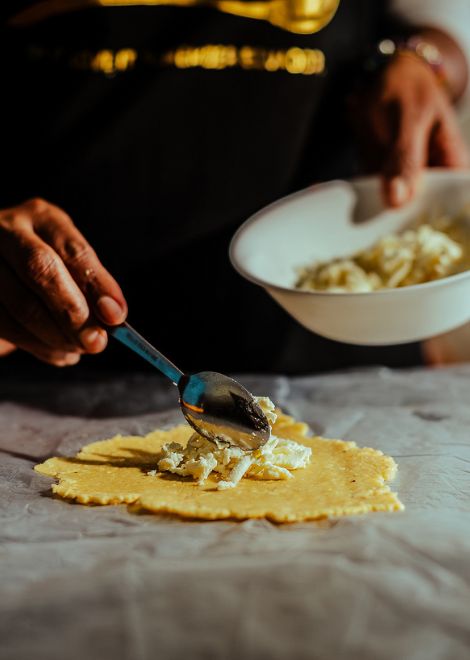 Handmaking empanadas de verde with a rich cheese filling.