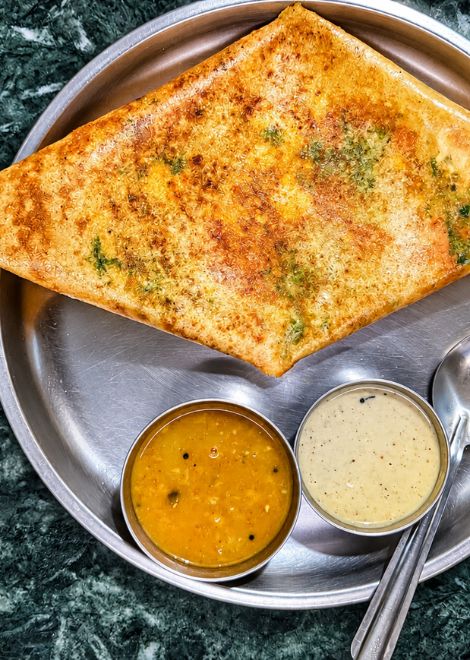 Crisp paneer masala dosa with coconut chutney and spiced sambar.