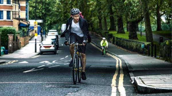 Man on bicycle, cycling along quiet road