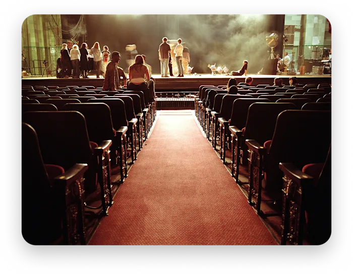An audience seated in front of a lit stage