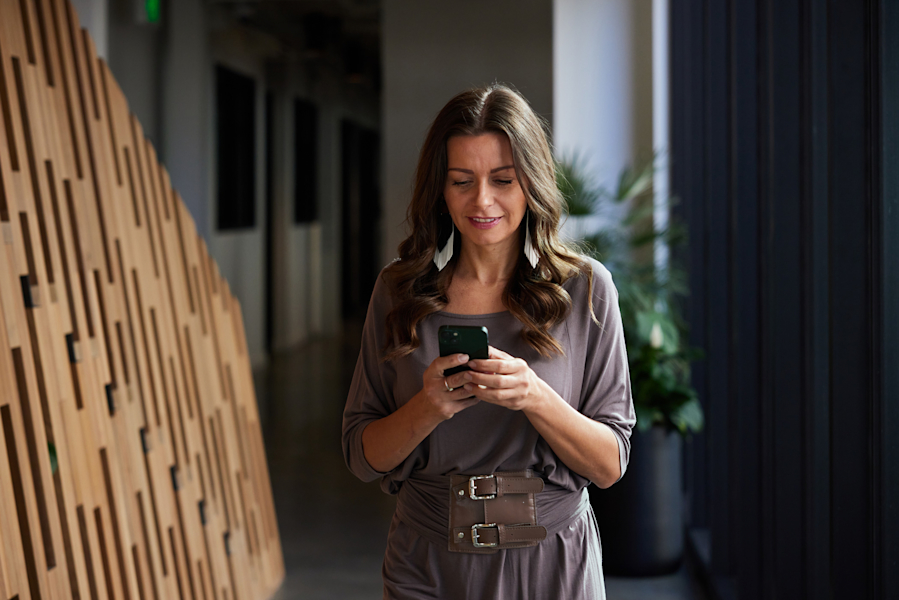 Woman holding phone walking through apartment complex