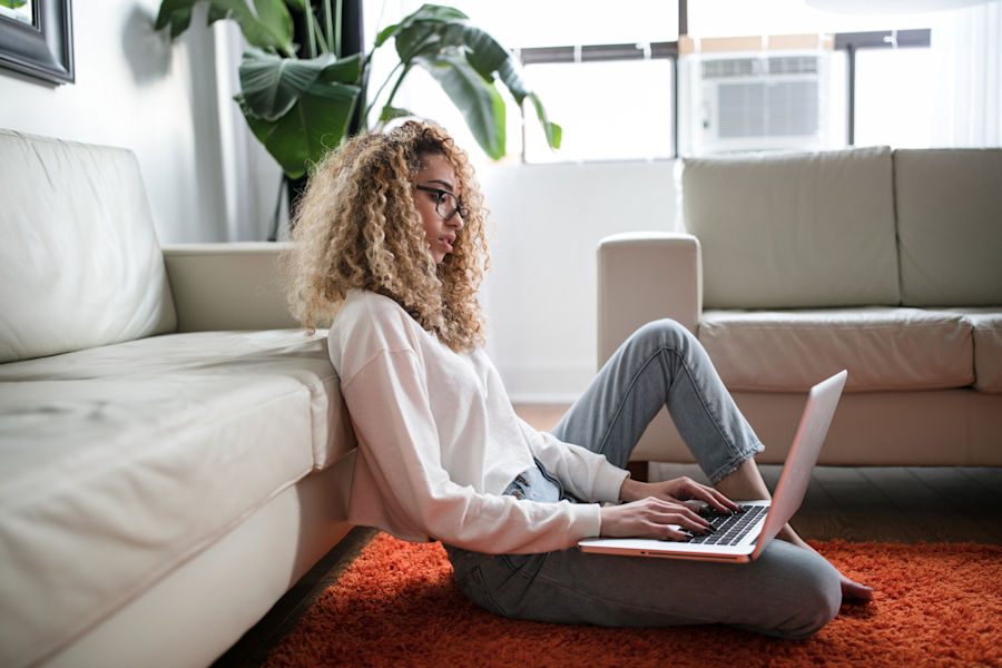 woman on floor looking at laptop