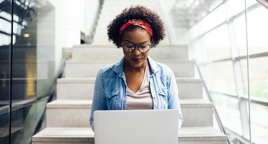 Student with laptop on staircase