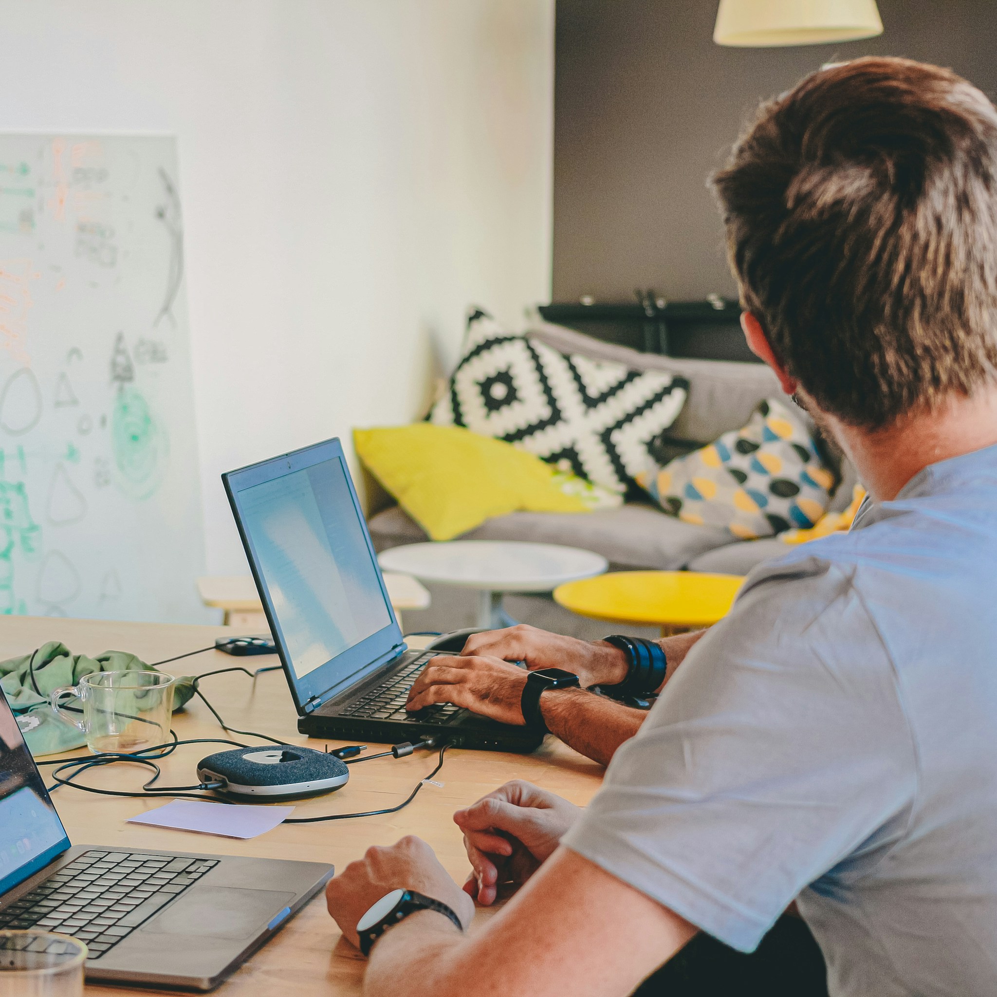 Engineers collaborating in a modern, well-lit office, working on multiple screens displaying code.