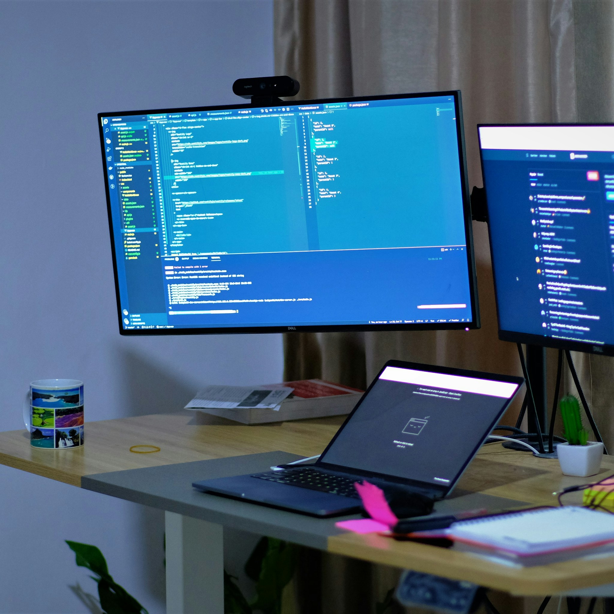 Developer focused on a laptop in a modern, well-lit office environment.