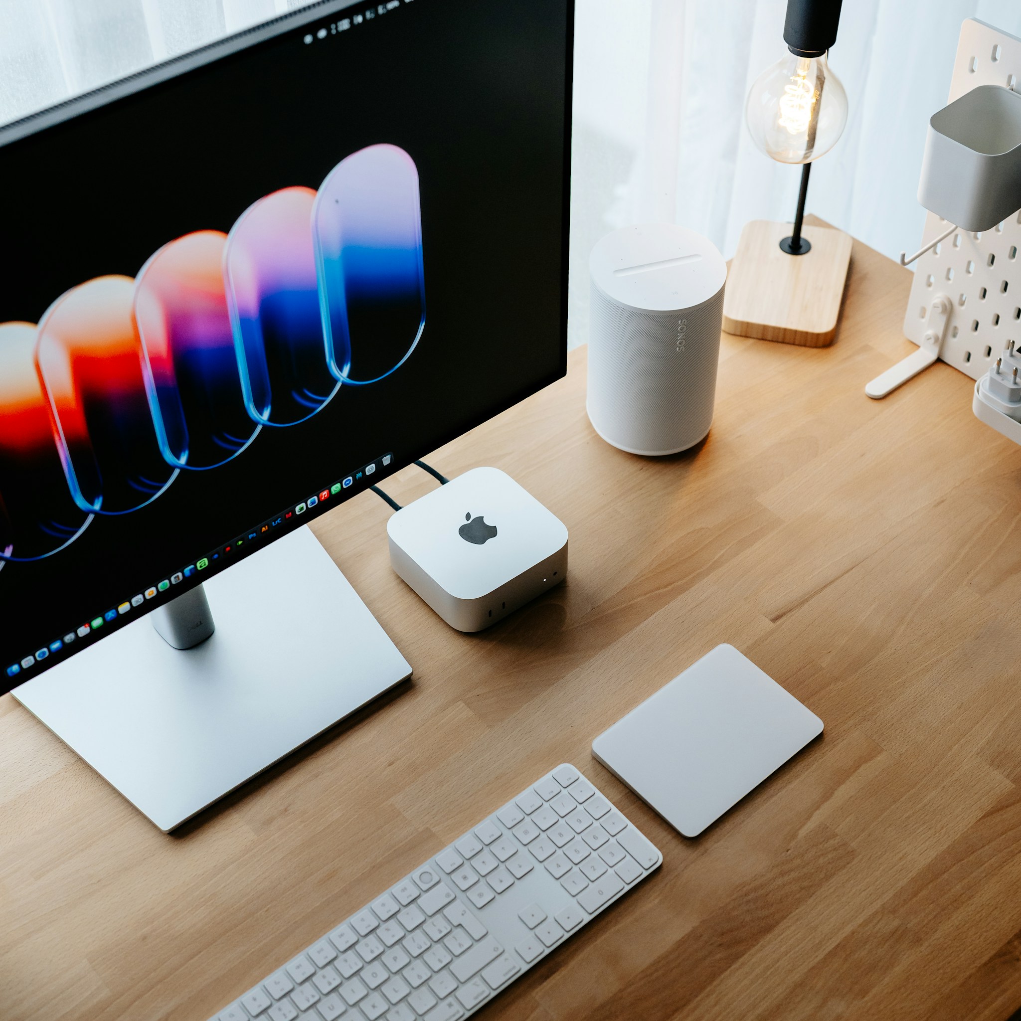 A modern desk setup featuring an Apple Mac mini, keyboard, and monitor, illustrating a local AI workstation.