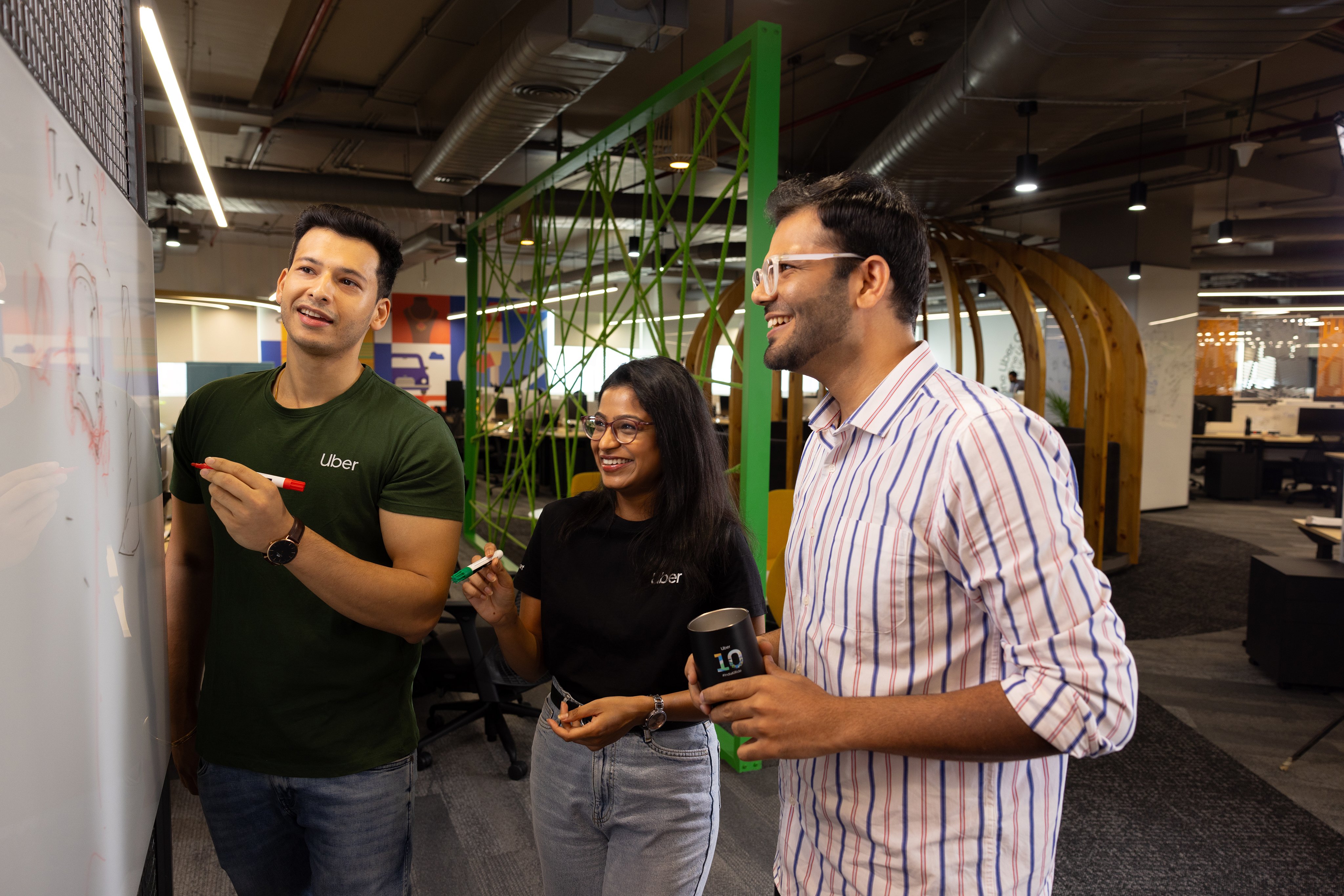 Uber engineers collaborating in a modern, open-plan office environment.