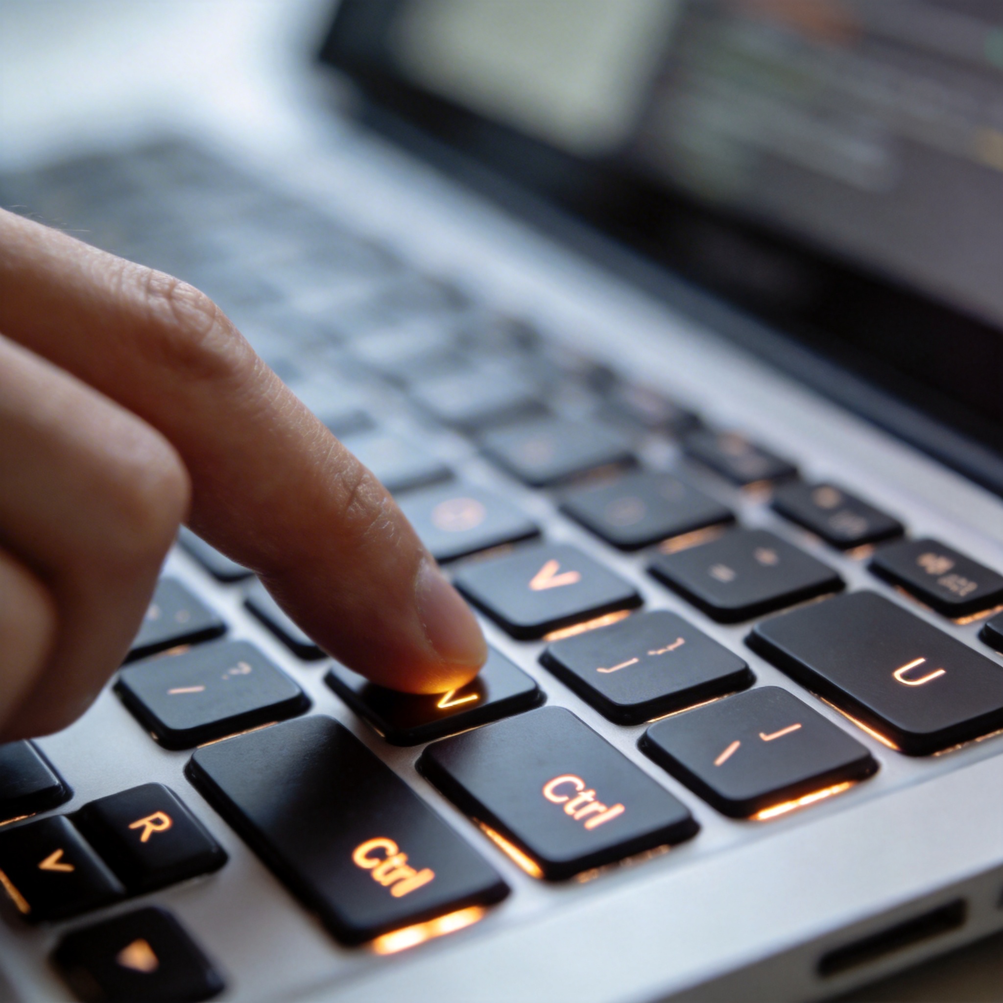 Close-up of a hand pressing keyboard keys, highlighting 'Ctrl' and other shortcut keys, symbolizing enhanced efficiency.