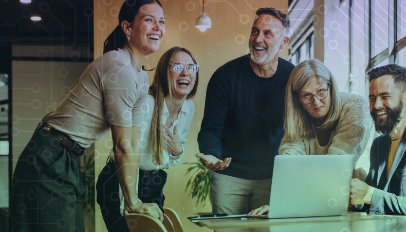 A group of happy people looking at a laptop 