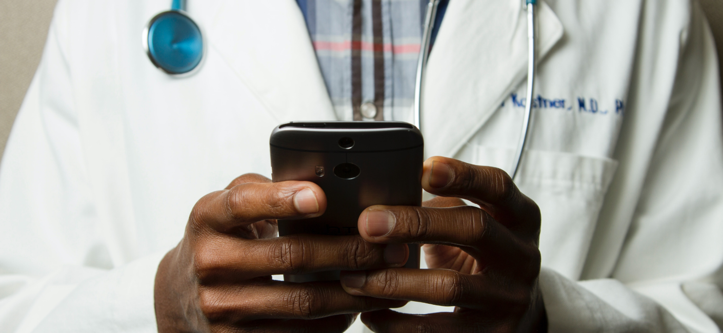 A doctor uses his mobile phone.