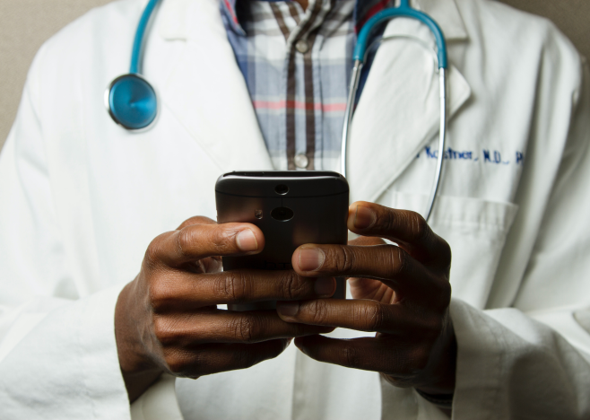 A doctor uses his mobile phone.