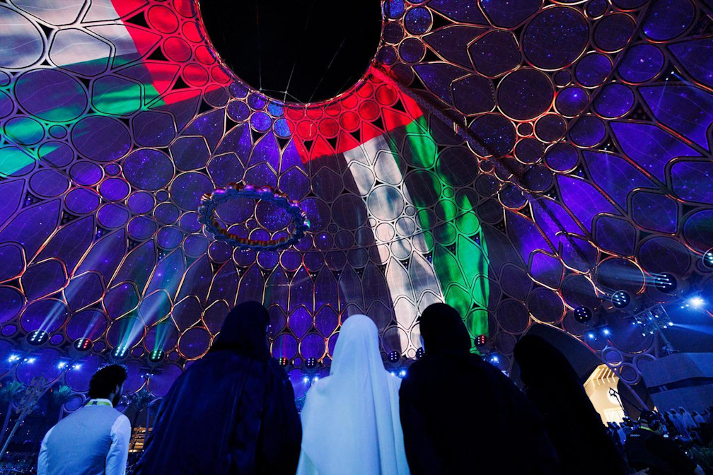 Visitors looking at the UAE flag on Al Wasl