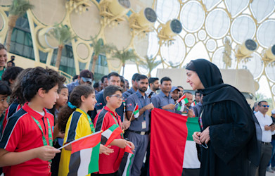 Her Excellency Reem Al Hashimy greeting school children on UAE flag day at Al Wasl flag raising ceremony 