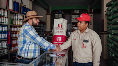 two men shaking hands inside a store