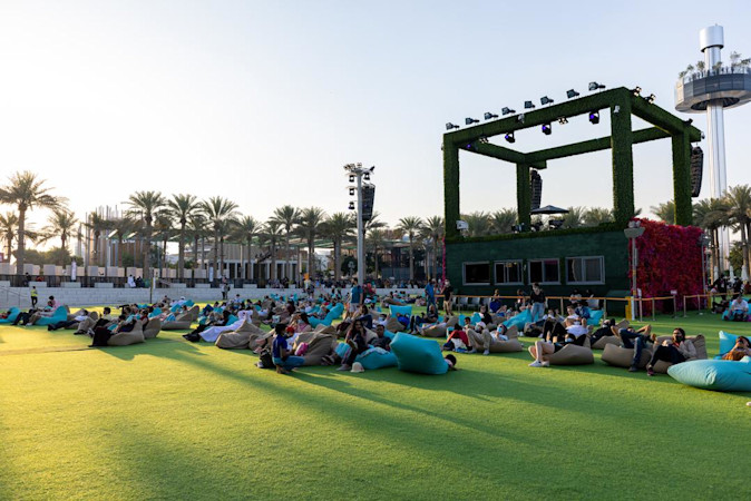 Lots of people on bean bags in the park grass area