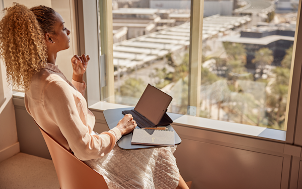 Freelancers Woman sitting next to a window in one of Expo City building working on her laptop