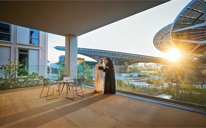 offices-gallery-district-04 Man and woman with emirating traditional clothes at a big terrace with Terra solars behind them