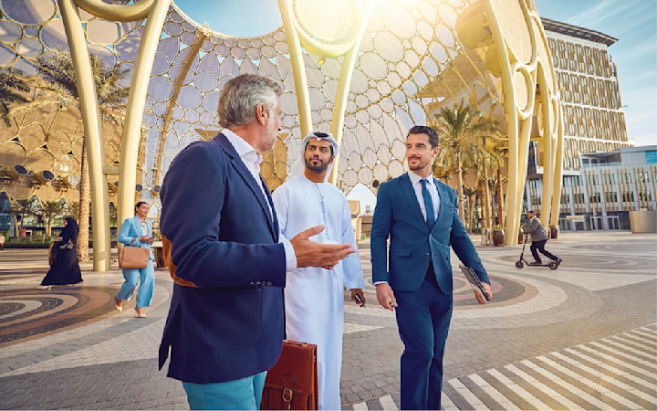 offices-gallery two men with suits and one wearing emirati traditional clothes around the AL Wasl plaza discussing topic