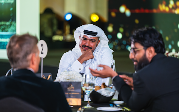 experienced-professionals An Emirati man with two other foreigners on a table having a conversation