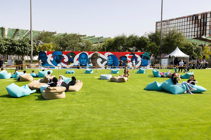 Street art exhibition with people relaxing on bean bags on the grass