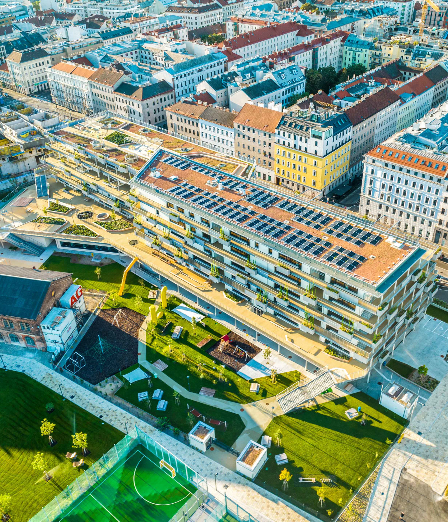 Foto: Außenansicht des Gebäudes mit begrünten Fassaden und großzügigem Vorplatz