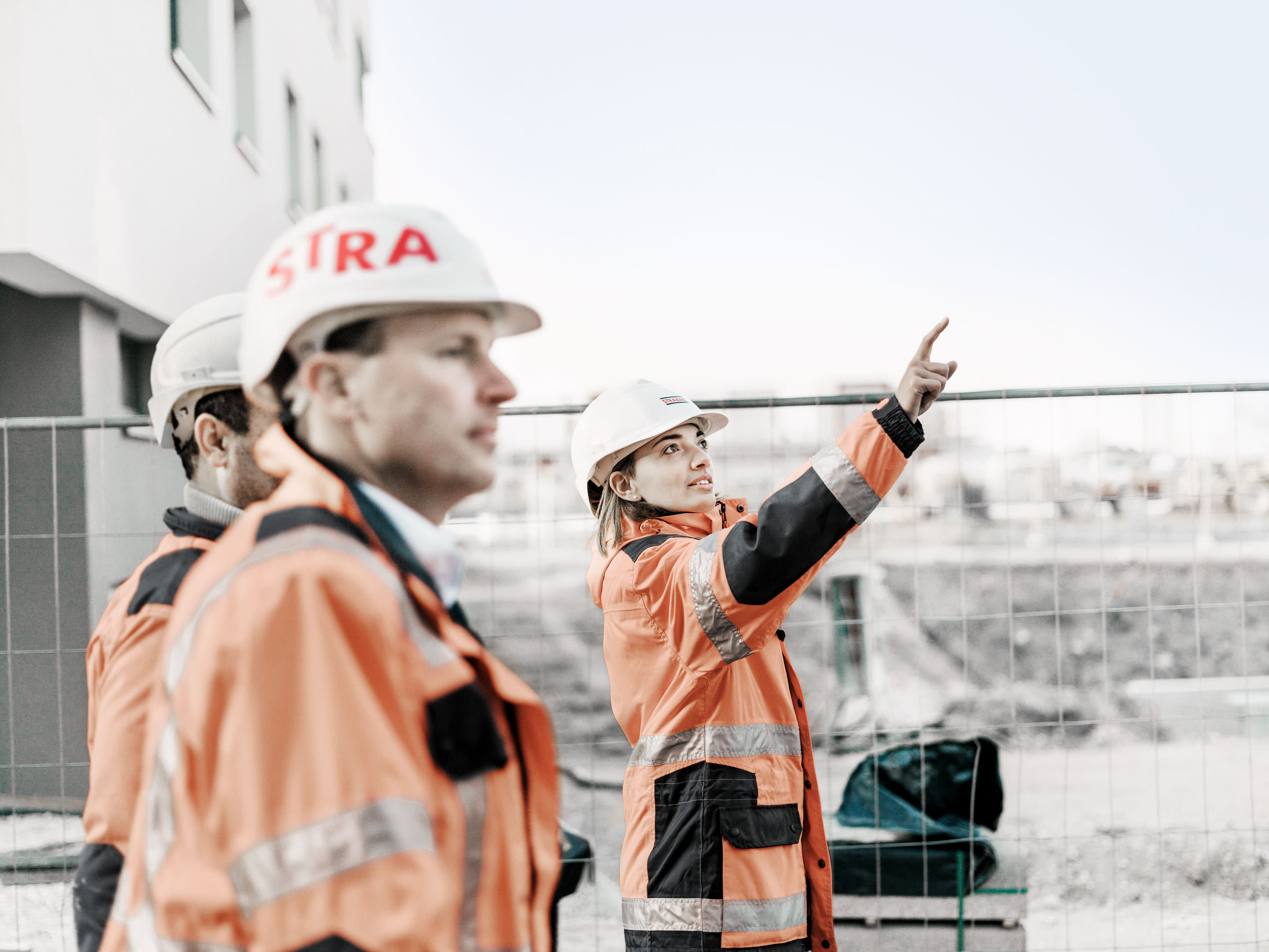 Bild: STRABAG Mitarbeiter auf der Baustelle vor einem Gebäude