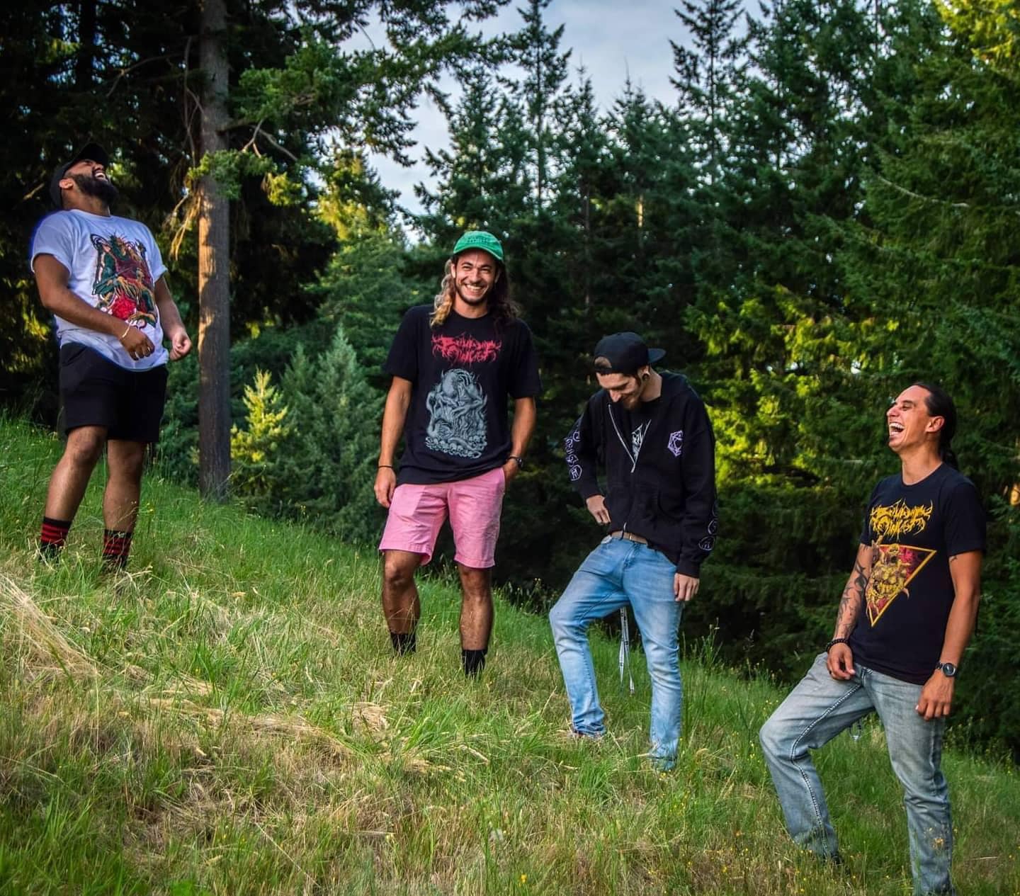 Band members laughing during photoshoot on hill. Left to right: Krishna, Sean, Jake, and Ben.