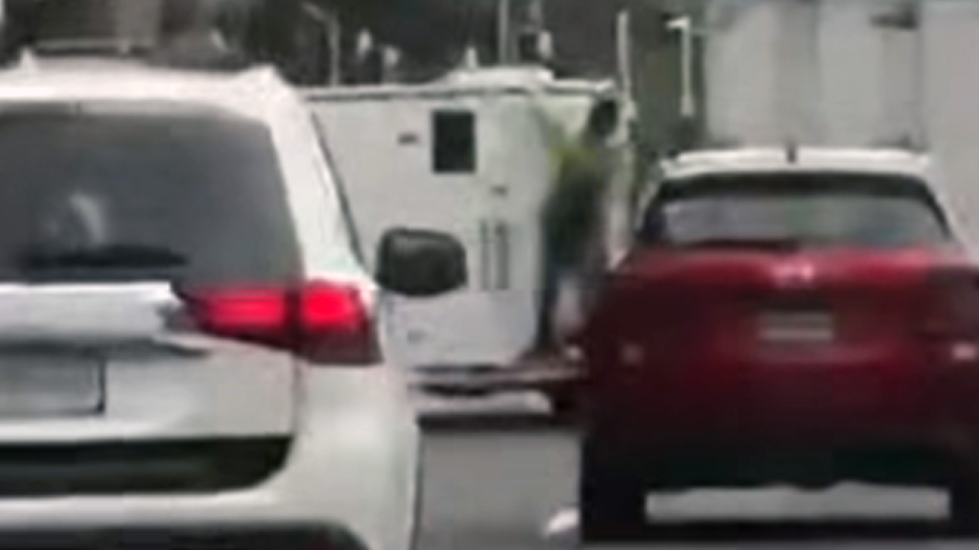 WATCH: Man takes 'risky ride' on back of prisoner van in Auckland traffic