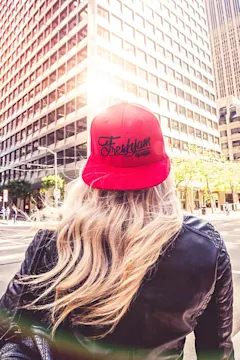 Person in red cap viewing city skyscrapers