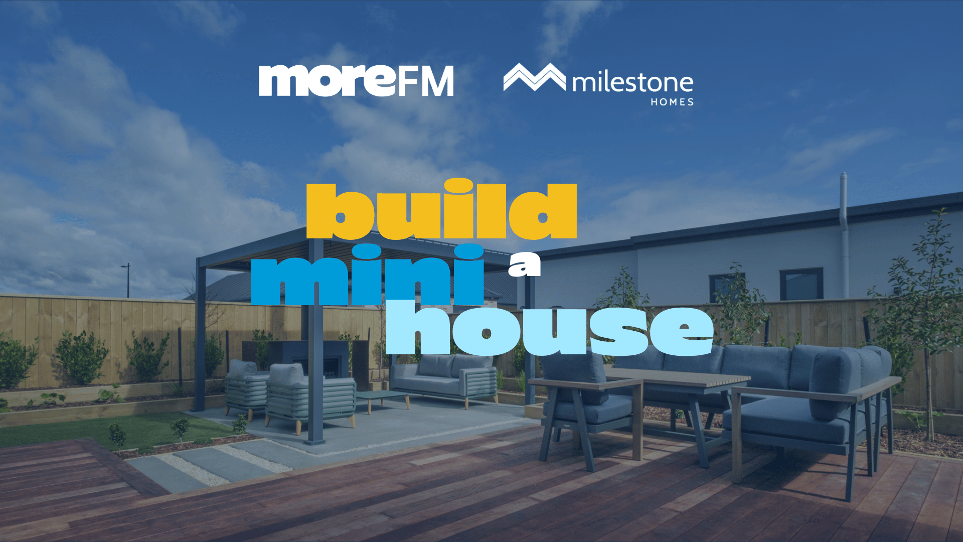 A promotional image features "moreFM" and "Milestone HOMES" logos, with the text "build mini a house" in various colors, set against a modern outdoor living area with a deck, patio furniture, and a pergola under a blue sky.