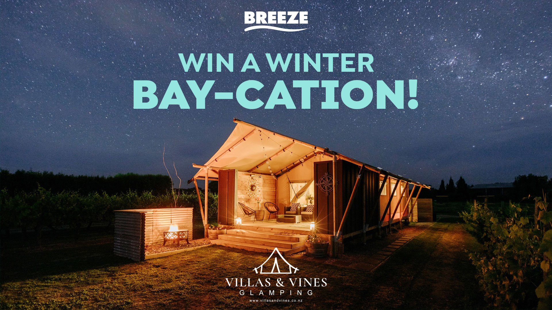 A luxurious glamping tent with a fire pit under a starry night sky, nestled in a vineyard, advertising a "Win a Winter Bay-cation!" prize.