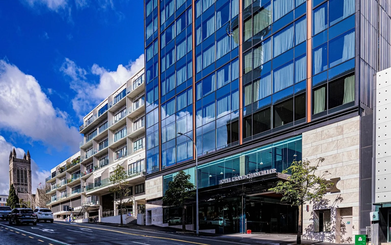 The exterior of Auckland's Hotel Grand Chancellor on a blue sky day.
