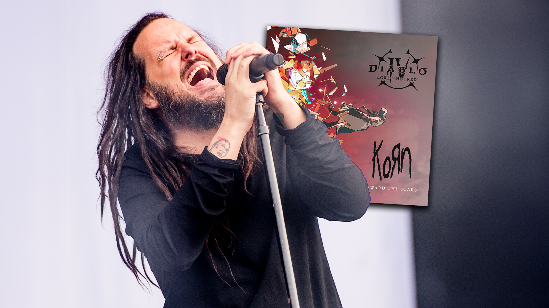 Jonathan Davis of Korn sings passionately into a microphone, with a poster showing "Diablo IV Lord of Hatred" and "KoЯn Reward the Scars" next to him.