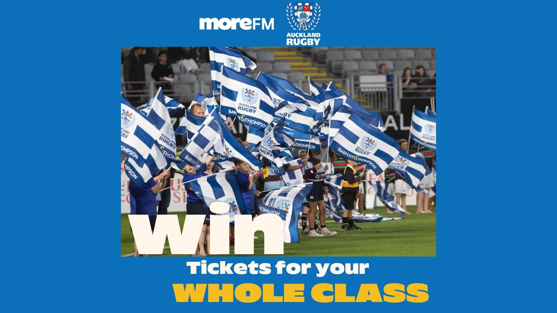 A group of children wave blue and white Auckland Rugby flags on a field, with overlaid text "Win Tickets for your WHOLE CLASS," and logos for moreFM and Auckland Rugby.
