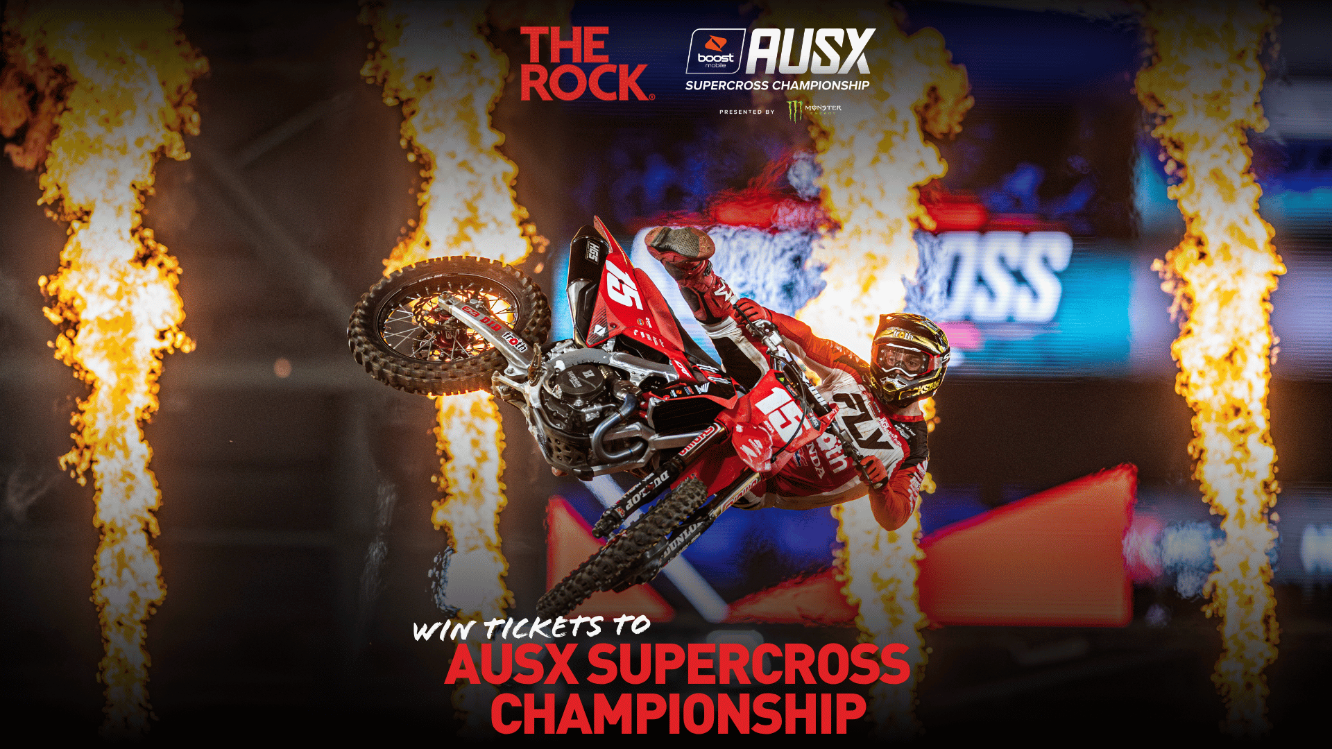 A motocross rider on a red dirt bike performs an aerial trick, surrounded by flames, with "AUSX SUPERCROSS CHAMPIONSHIP" logos at the top and "WIN TICKETS" text at the bottom.