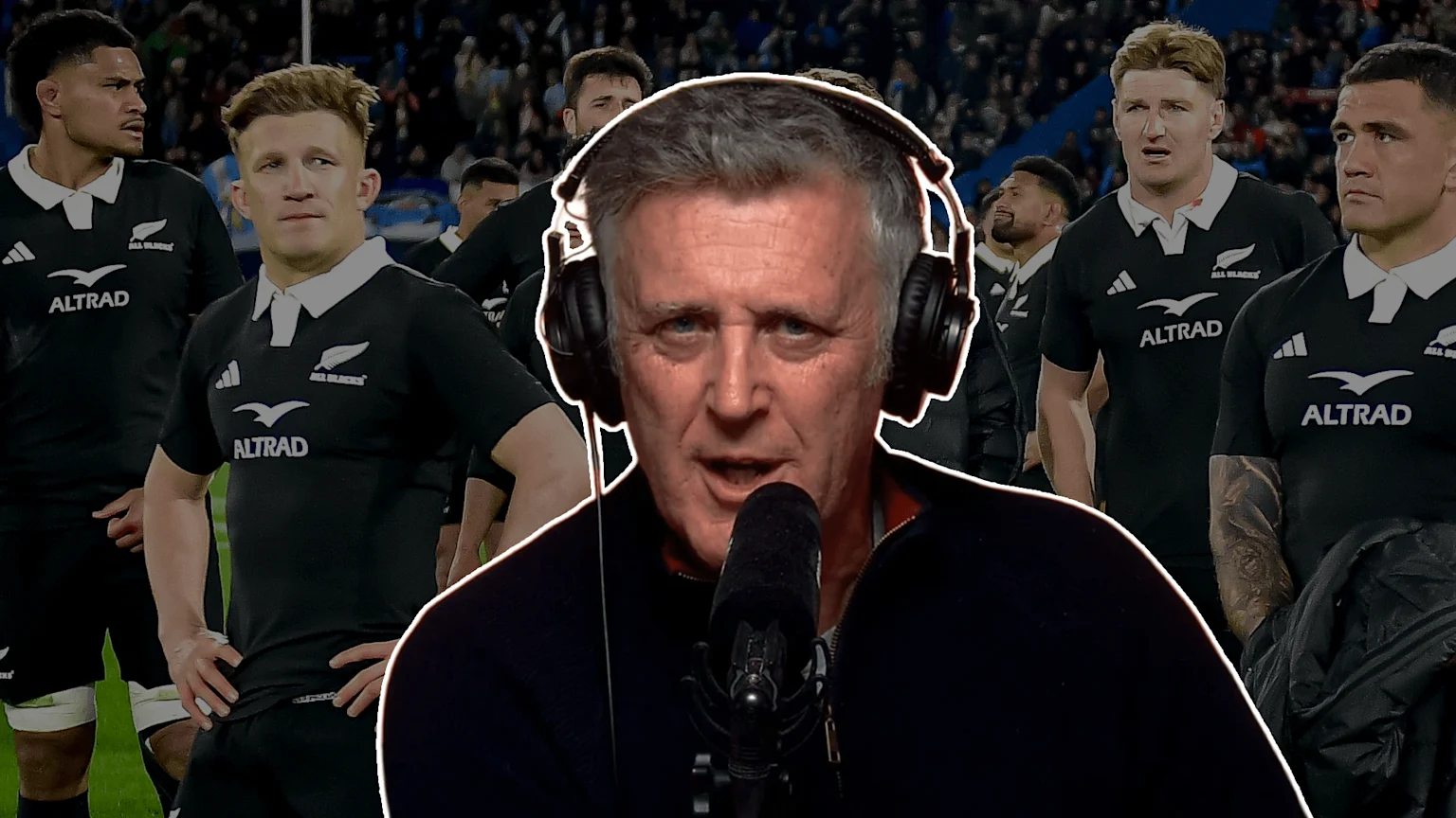 Tony Johnson standing in front of All Blacks players.