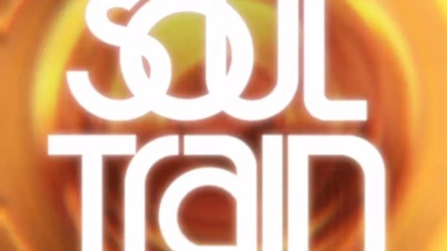 A logo featuring the white text "Soul Train" in two distinct fonts, set against a blurry, warm-toned background with orange and yellow hues.