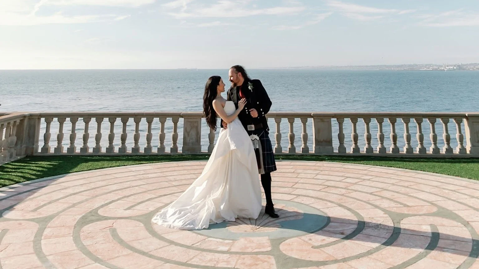 Bride and groom embracing by the ocean