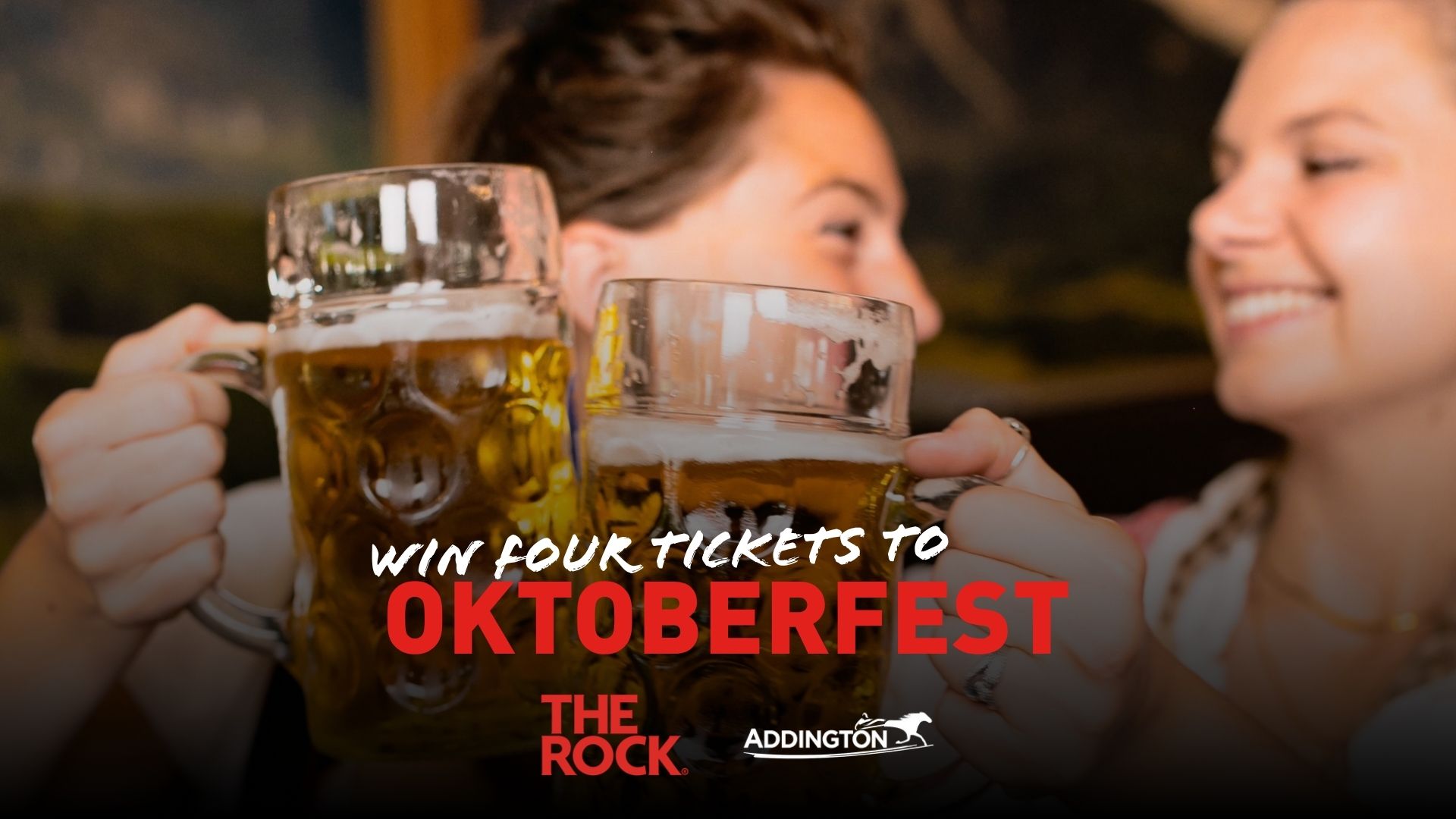 Two smiling women clink large steins of beer, with promotional text "WIN FOUR TICKETS TO OKTOBERFEST" and logos for "THE ROCK" and "ADDINGTON" overlaid.