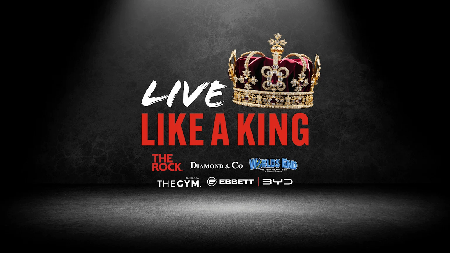 Text "LIVE" in white and "LIKE A KING" in red, next to a gold and red jeweled crown, with sponsor logos including The Rock, Diamond & Co, Worlds End, The Gym, Ebbett, and BYD, on a dark textured background.