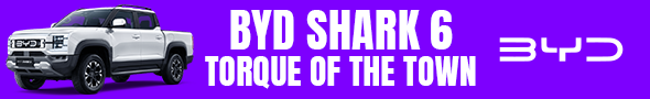A white BYD Shark 6 double-cab pickup truck on a purple background, with "BYD SHARK 6 TORQUE OF THE TOWN" text in white and a stylized BYD logo.