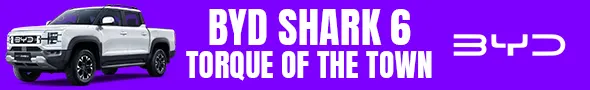 A white BYD Shark 6 double-cab pickup truck on a purple background, with "BYD SHARK 6 TORQUE OF THE TOWN" text in white and a stylized BYD logo.