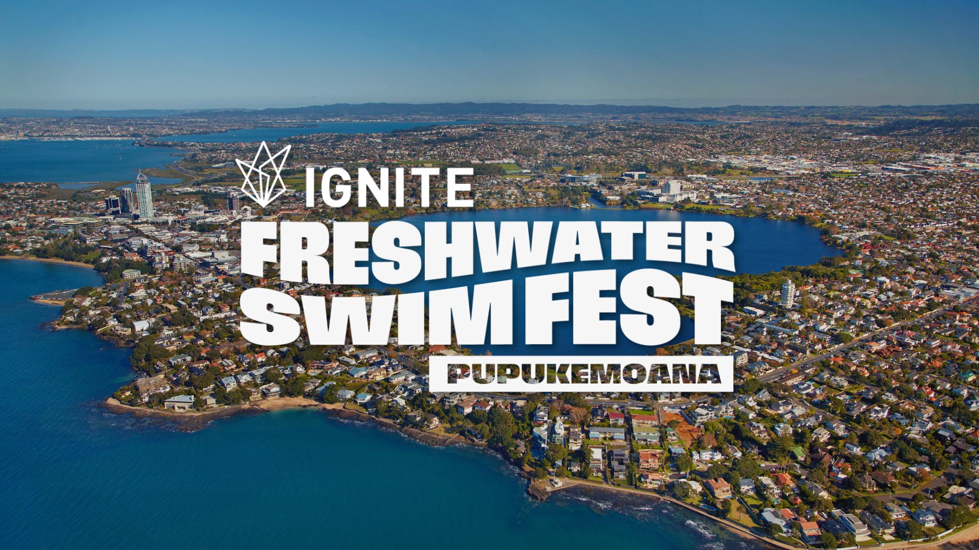 Aerial view of a city with a large freshwater lake and coastline, featuring prominent white text: "IGNITE FRESH WATER SWIM FEST PUPUKEMOANA".