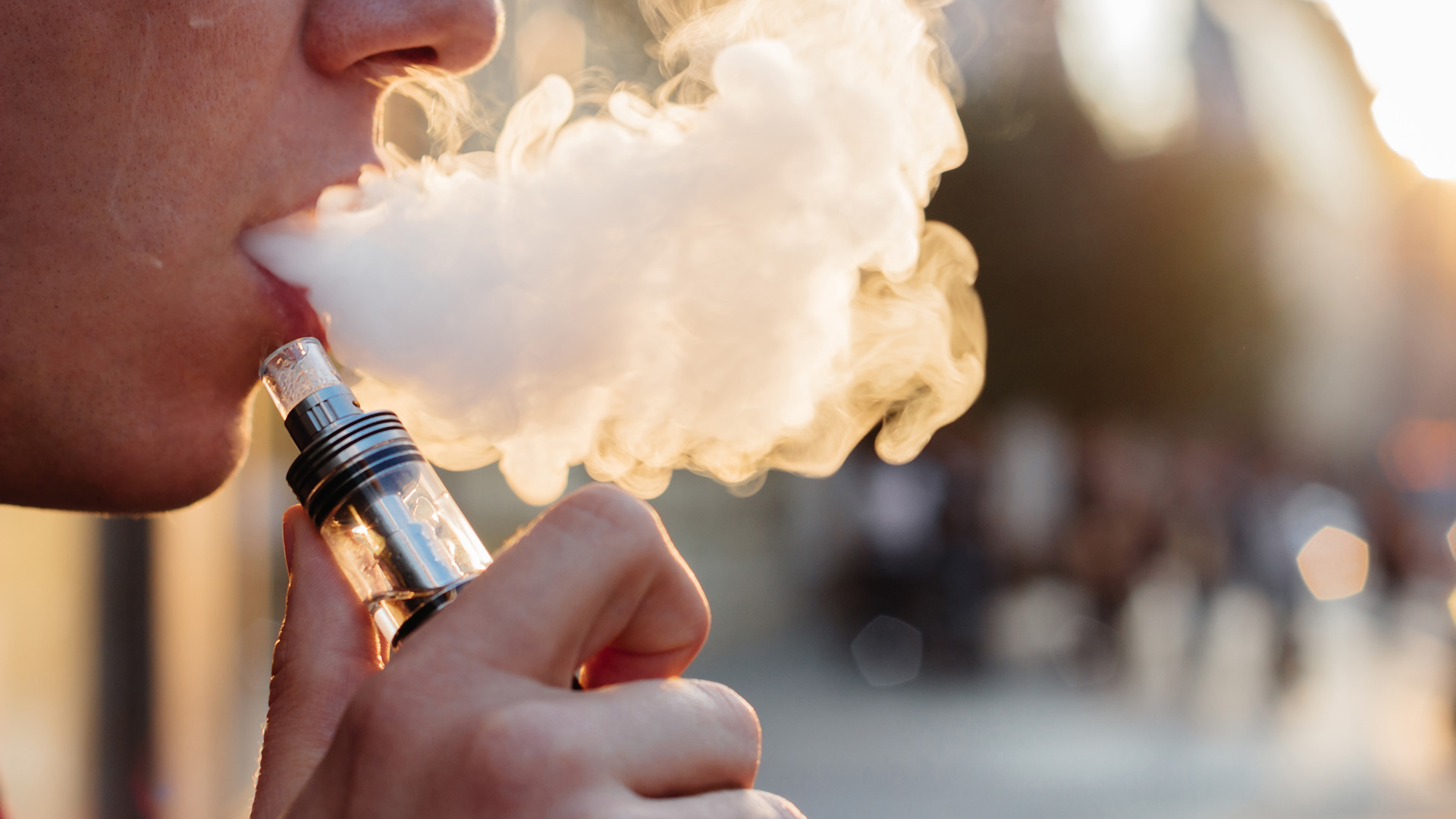 Person exhaling vapor from e-cigarette