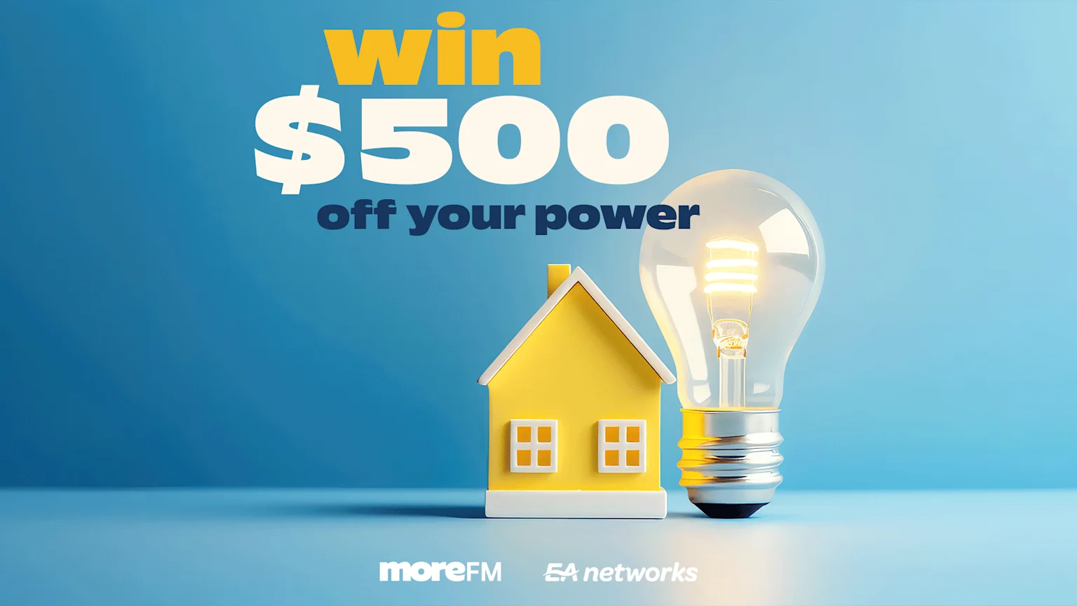 "Win $500 off your power" text is displayed above a yellow model house and an illuminated light bulb, with moreFM and EA networks logos at the bottom on a blue background.