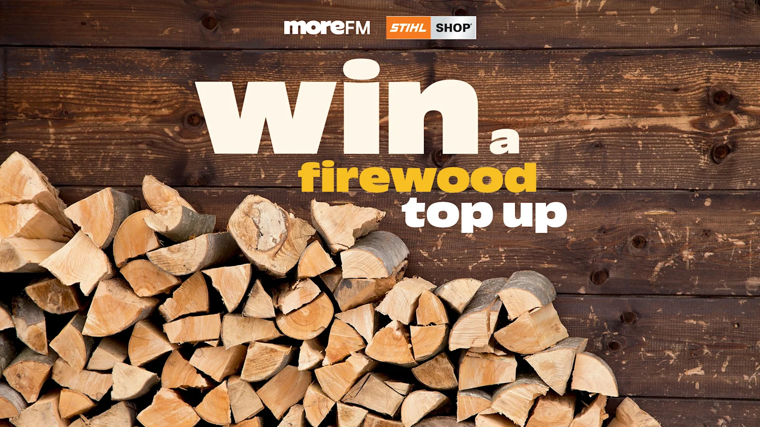 A promotional image showing a large stack of chopped firewood against a dark wooden background, with "Win a firewood top up" text and logos for moreFM and STIHL SHOP.
