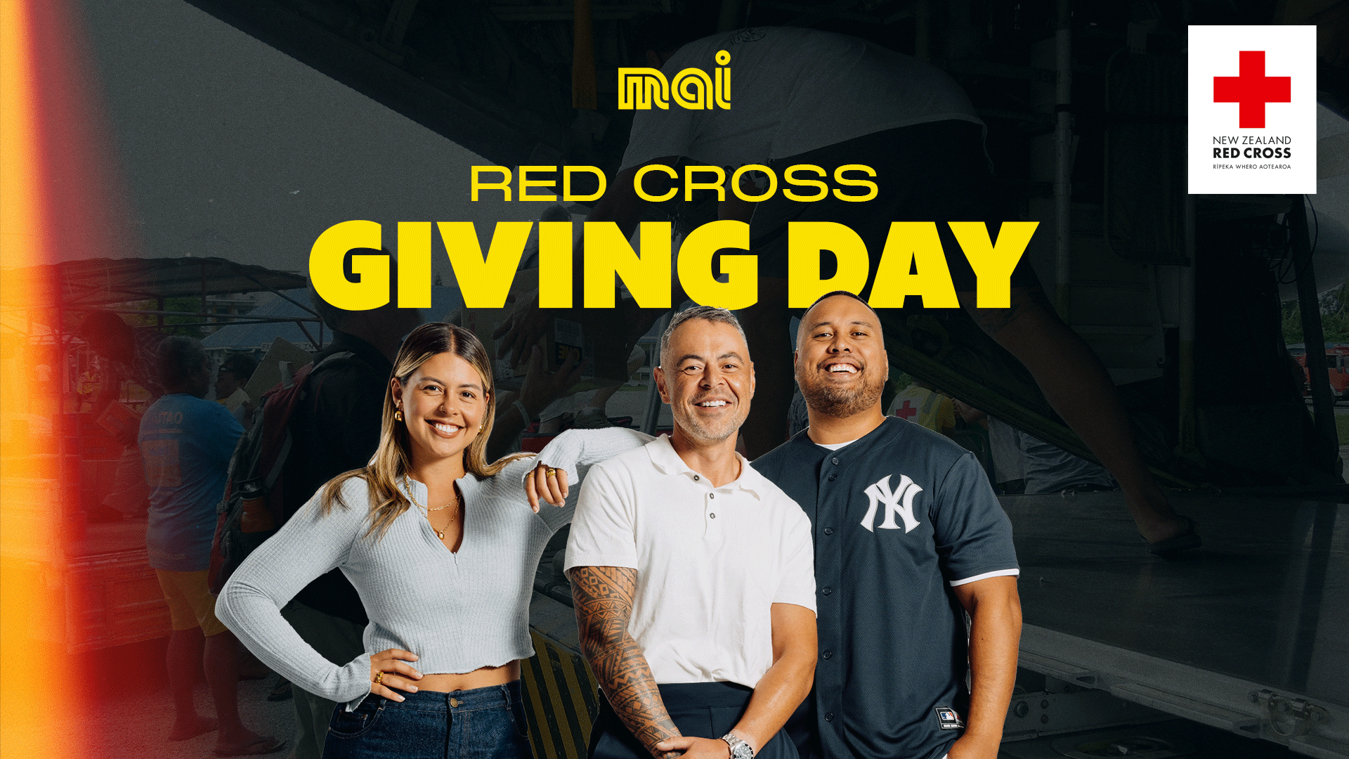 Three smiling individuals are featured in the foreground, with large yellow text reading 'RED CROSS GIVING DAY' above them, and Mai FM and New Zealand Red Cross logos against a dark, blurry background of people.