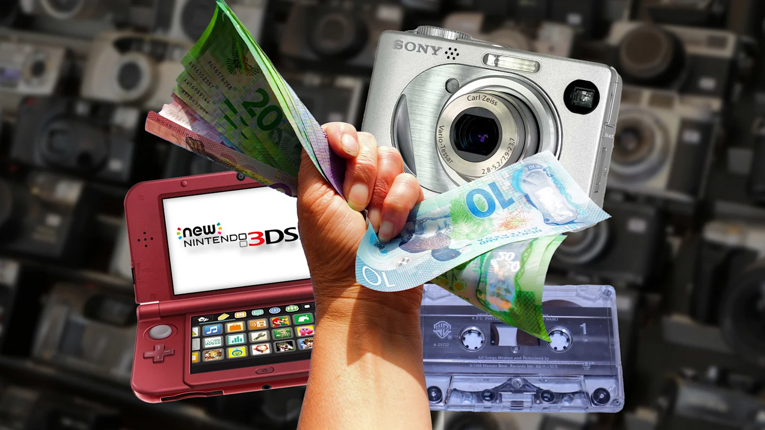 A hand clasps New Zealand dollar banknotes, positioned among a red New Nintendo 3DS, a silver Sony digital camera, and a clear audio cassette, all against a blurred backdrop of vintage cameras.
